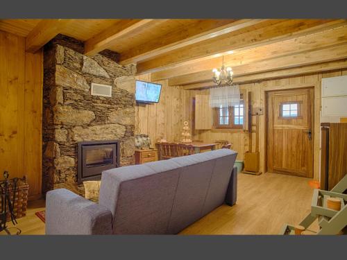a living room with a couch and a stone fireplace at Casas Dos Barreiros in Melgaço