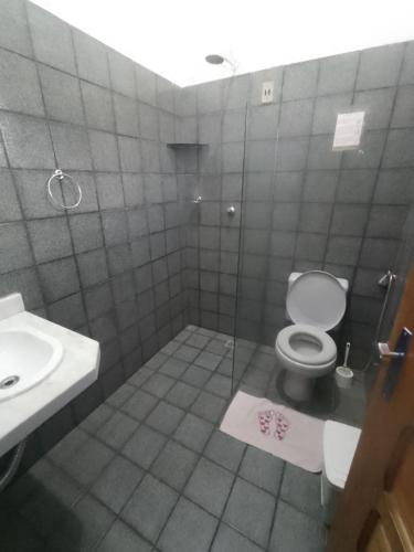 a bathroom with a toilet and a sink at Chácara da Bel in Pitimbu