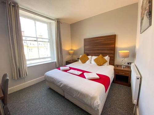a hotel room with a bed and a window at The Broadway Hotel in Llandudno