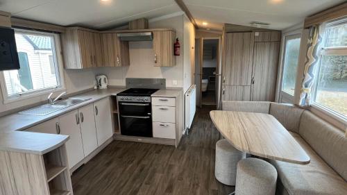 a small kitchen with a wooden table and a dining table at Beamish Holiday Park in Stanley