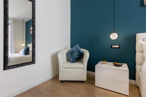 um quarto com uma cadeira branca e um espelho em Daddi rooms & apartment em Cagliari