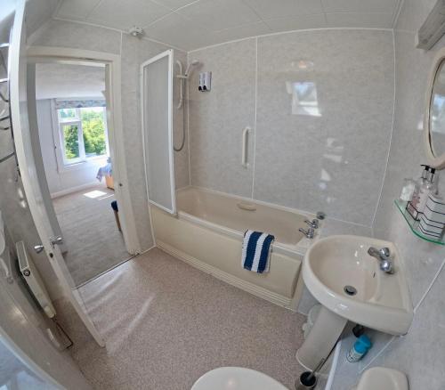 a bathroom with a sink and a shower and a toilet at Allandale House in Brodick
