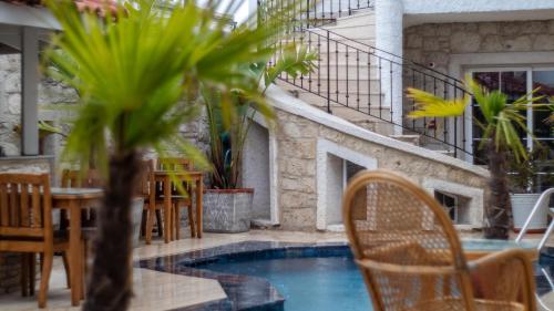 a patio with a table and chairs and a pool at Avlu Alaçatı Boutique Hotel in Alacati