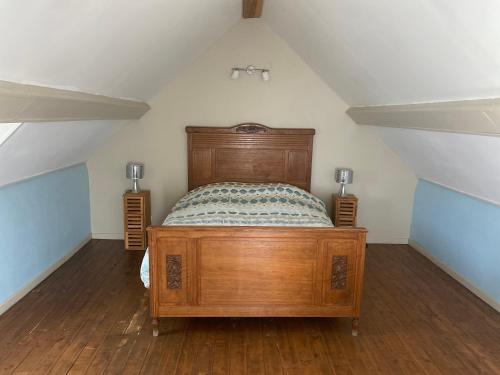a bedroom with a wooden bed in a attic at Chambre d’hôtes st pierre le moutier in Saint-Pierre-le-Moûtier