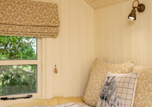 a room with a pillow and a window at The Orchards Retreat Shepherds Hut in Saint James