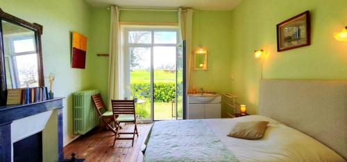a bedroom with a bed and a bathroom with a window at logis Ozanie in Javrezac