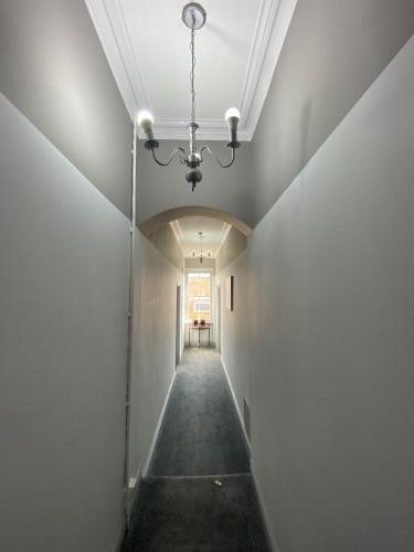 an empty hallway in a building with a chandelier at The Broadway Hotel in Llandudno