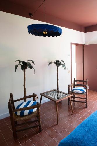 - deux chaises et une table dans une chambre avec des palmiers dans l'établissement Les Chambres de la Relève, à Marseille