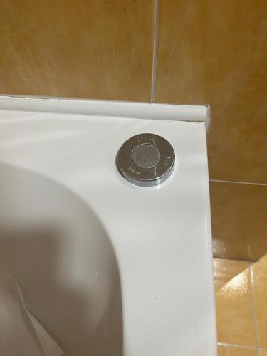 a coin is sitting on top of a toilet at ALOJAMIENTO LOS DINOSAURIOS in Cuenca