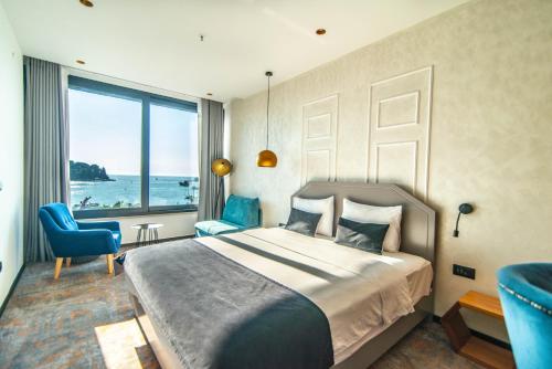 a hotel room with a bed and a large window at Hotel Delfin in Rovinj