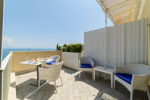 a patio with a table and chairs on a balcony at Residenza Al Pesce D'Oro in Amalfi