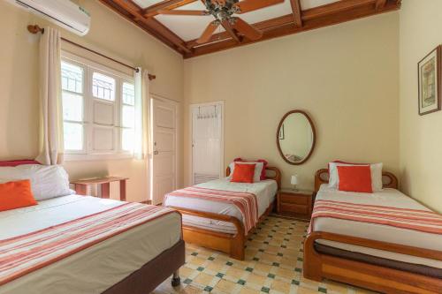 a room with two beds and a mirror in it at La casa azul in Cartagena de Indias