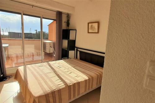 une chambre avec un lit et une grande fenêtre dans l'établissement Appart 139, Le Neptuna, au Cap d'Agde