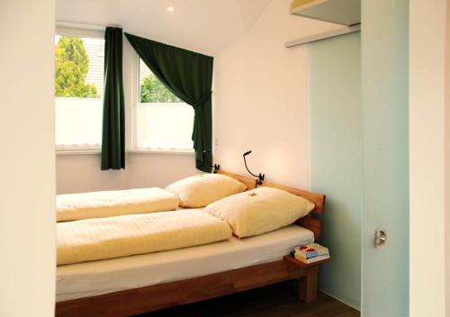 un letto con due cuscini sopra in una stanza di Ferienwohnungen Weichaer Hof a Weißenberg