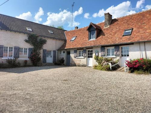 stary dom z żwirowym podjazdem przed nim w obiekcie la ferme des bigornes w mieście Châtillon-sur-Indre