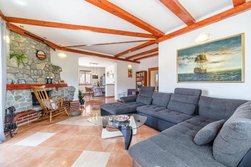 a living room with couches and a stone fireplace at Guest house Barbara in Nerežišća