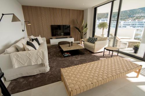 un soggiorno con 2 divani bianchi e una TV di Mara's Apartments Higueron West - Scandinavian Luxury - Views of the Sea and Natural Landscapes a Fuengirola