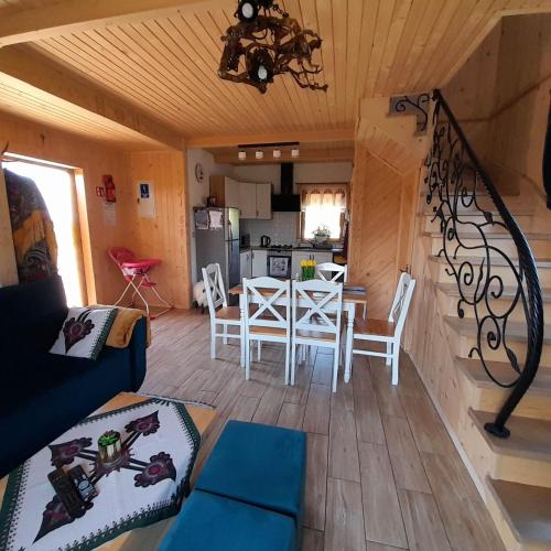 a living room with a table and a kitchen at Domek u Śpiewoka 1 in Maruszyna