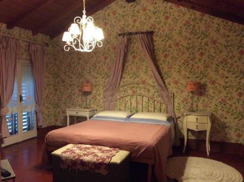 1 dormitorio con cama y lámpara de araña en Aria di Campagna, en Lodi