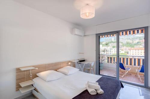 a bedroom with a white bed and a balcony at M6 1BDR Sea View balcony 2mins walk beach garage AC in Roquebrune-Cap-Martin