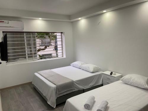 2 camas en una habitación con ventana en Apartamento de 2 habitaciones Miraflores 401, en Cali