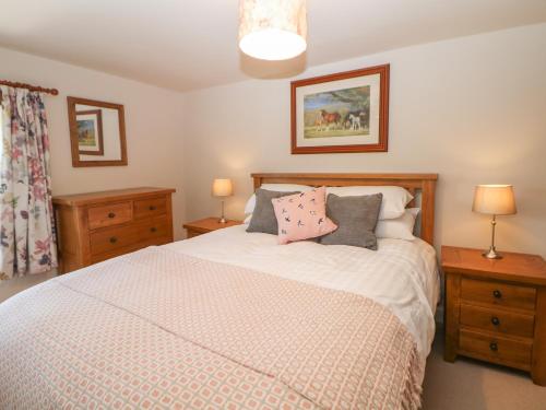 1 dormitorio con 1 cama con 2 mesitas de noche y 2 lámparas en Rose Cottage, en Buxton