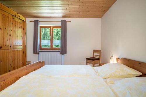 Un dormitorio con una cama grande y una ventana en Tobelbach, en Weiler-Simmerberg