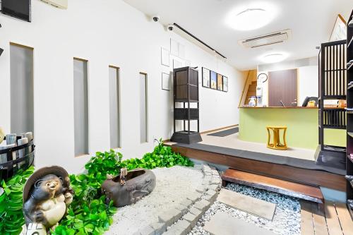 a living room with a monkey statue on the floor at Wafu Ryokan Uehonmachi in Osaka