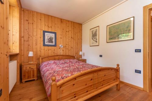 a bedroom with a wooden bed in a room at Condominio Orsa Maggiore 12 in Falcade