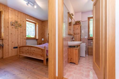 a bathroom with a bed and a sink in a room at Condominio Orsa Maggiore 12 in Falcade