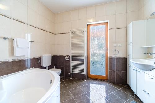a bathroom with a tub and a toilet and a sink at Guest house Barbara in Nerežišća