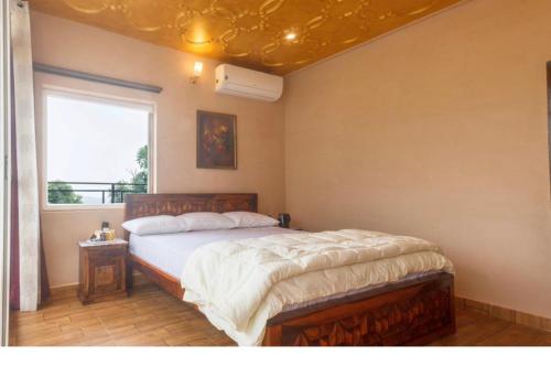 a bedroom with a bed and a window at Riva dreams in Dharamshala