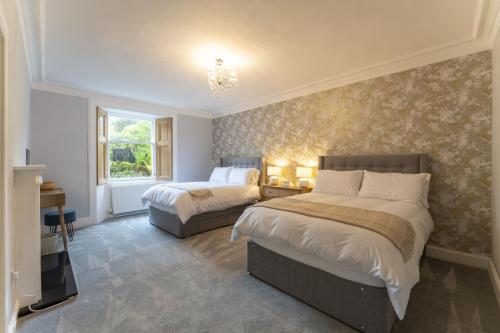 Un dormitorio con dos camas y un televisor. en The Lindsay House, en Stirling