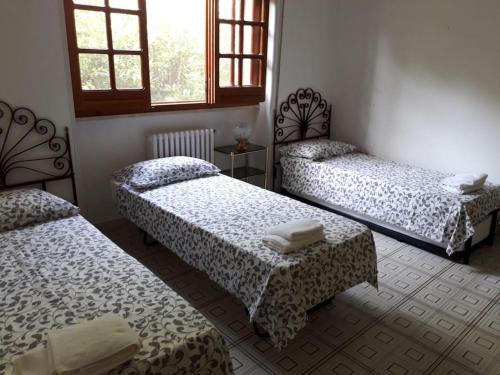 Zimmer mit 3 Betten und einem Tisch in der Unterkunft Grande villa con piscina privata in Maruggio