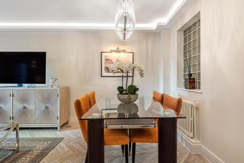 a dining room with a glass table and chairs at Flat 5 in London