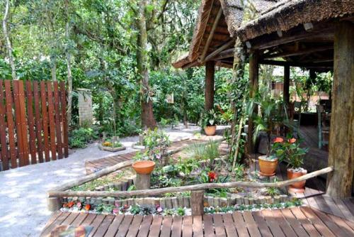 a garden with potted plants and a wooden fence at Pousada Favo De Mel in Ilha do Mel