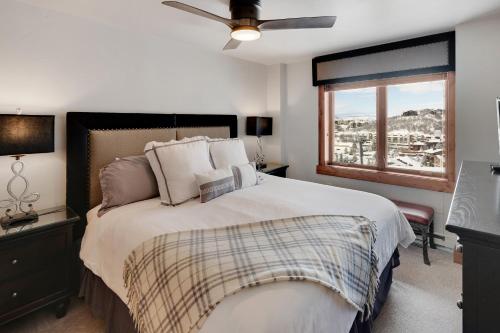 a bedroom with a bed with a ceiling fan and a window at Bear Claw 406 - Ski-in Ski-out Condo! in Steamboat Springs