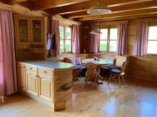 eine Küche mit einem Tisch und Stühlen in einer Hütte in der Unterkunft Bio Bauernhof Perneißl Apartment in Bischofshofen