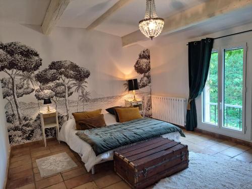 une chambre avec un lit et une grande fenêtre dans l'établissement Le Mas des Cosme, à Aramon