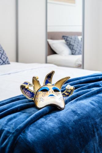 a gold and blue mask on a bed at Guest house Barbara in Nerežišća