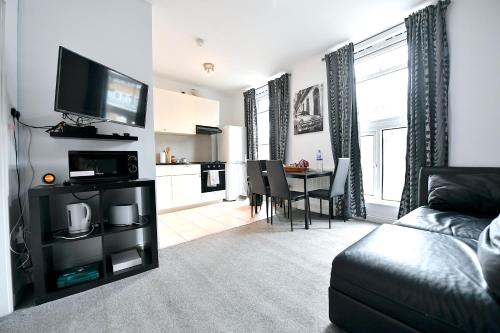 a living room with a couch and a dining room at City Central Apartments in London