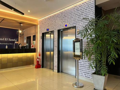 a lobby with two elevators and a potted plant at Hotel El Tambo 2 in Lima