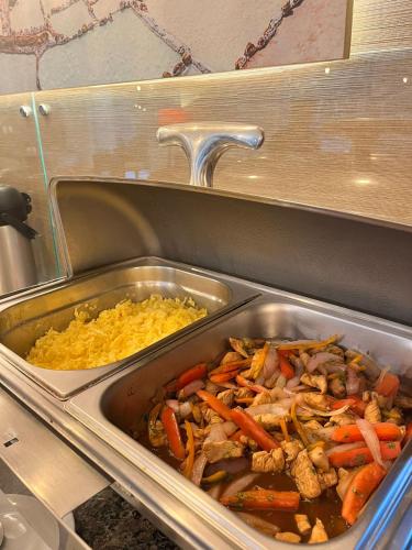 a metal tray of food with carrots and rice at Hotel El Tambo 2 in Lima