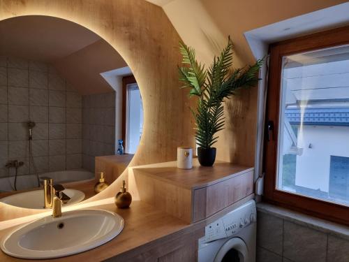 een badkamer met een wastafel, een bad en een raam bij Apartma Katarina in Bled