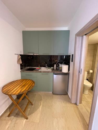 a kitchen with blue cabinets and a wooden stool at Ntina's Room in Nea Potidaea