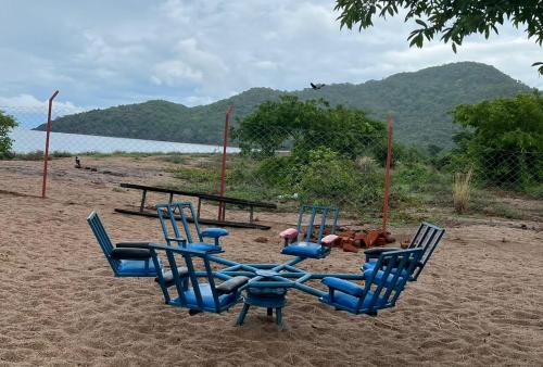 a group of chairs in the sand on a beach at MHALO BEACH LODGE 