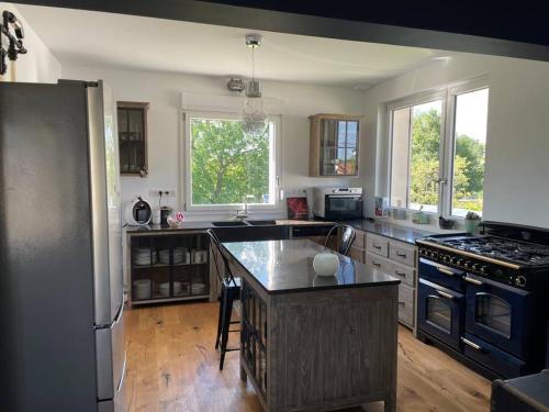 une cuisine avec une cuisinière et un réfrigérateur dans l'établissement Maison individuelle avec grand jardin, à Vitrimont