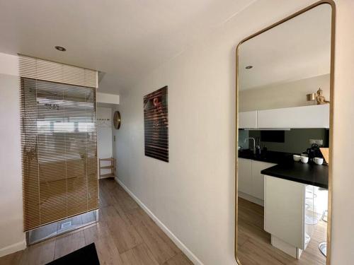 une chambre avec un miroir et une cuisine avec un comptoir dans l'établissement Appart 373, Port Nature 3 au village naturiste, au Cap d'Agde