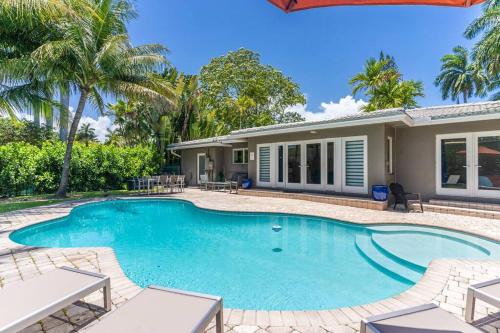 a swimming pool in front of a house at Luxury 3 Bedroom Home 5 minutes to Ocean with Heated Pool in Hollywood