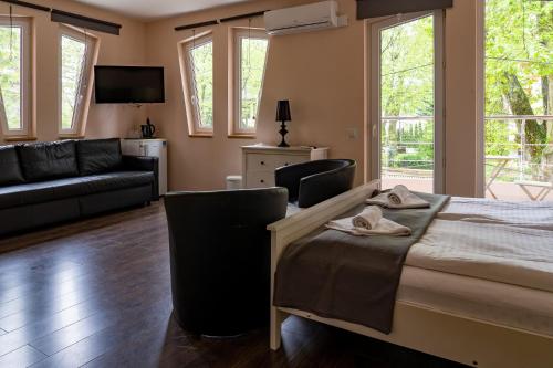 a bedroom with a bed and a living room at Accomo Apartmanház in Siófok